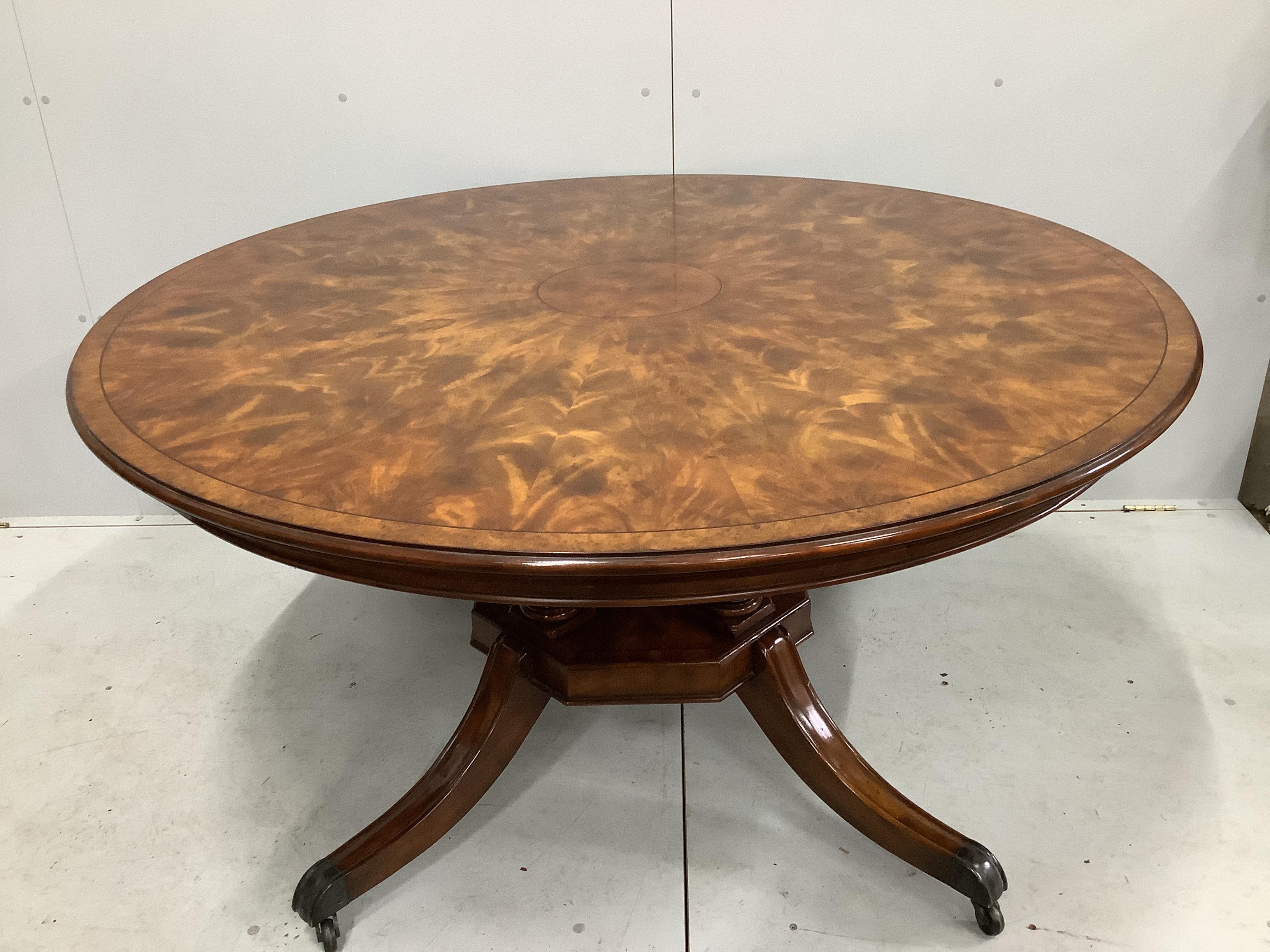 A reproduction George III style circular mahogany extending dining table with detachable segmental outer ring and eight Empire style cherry dining chairs with tan leather seats, table 142cm diameter, 202cm diameter exten